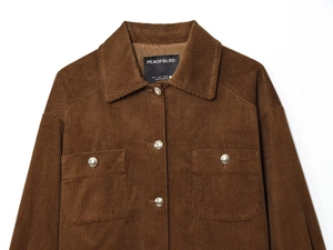 Detail of brown corduroy jacket texture with silver metal buttons and flap pockets
