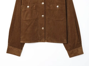 Detail of brown corduroy jacket showing texture, metal buttons and flap pockets