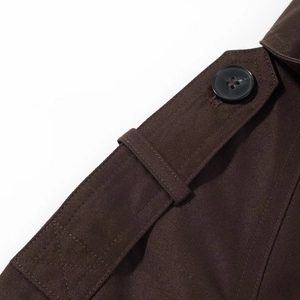 Close-up of deep brown trench coat shoulder epaulet with high-density cotton texture