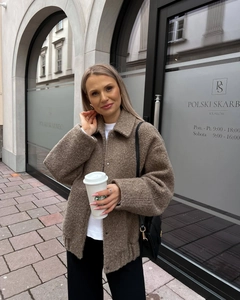 Close-up of brown textured fleece shacket with lapel collar and metal buttons in street style