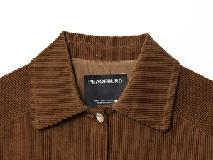 Macro shot of brown corduroy jacket collar with metal button and woven size label