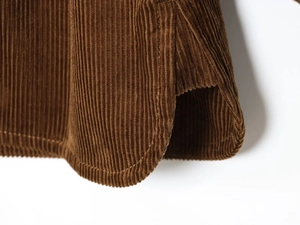 Detail view showing side slit and vertical texture of brown corduroy shirt jacket