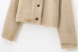 Détail de la veste courte en fausse fourrure camel clair avec boutons en écaille
