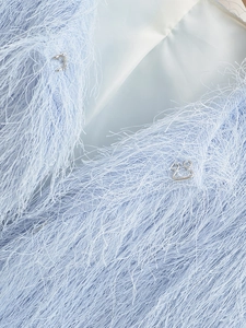 Close-up of the light blue faux fur jacket showing the metal hook fastener and silk lining