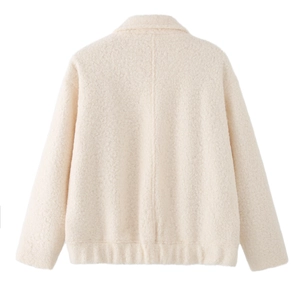 Detail view of the plush faux wool texture and elastic hem on the cream fleece jacket