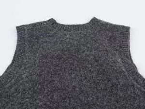 Detailed view of dark grey knit vest featuring premium wool texture and ribbed neckline