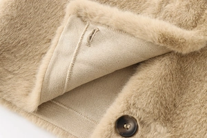 Détail d'une veste courte en fausse fourrure avec bouton en résine et texture peluche