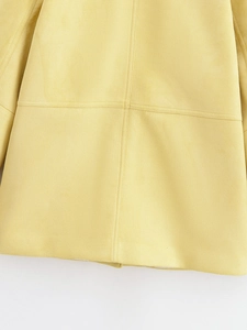 Detailed macro view of yellow suede coat fabric showing high-quality stitching