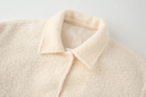 Detail of cream teddy fleece jacket showing soft texture and lapel sewing quality