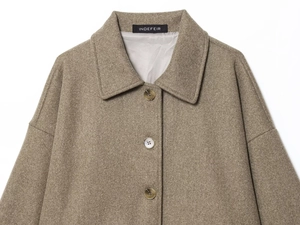 Detail of amber buttons and wool blend fabric on a brown lapel collar short coat
