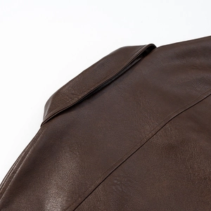 Close-up of vintage brown PU leather jacket showing collar detail and pebble grain texture