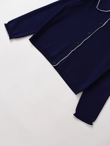 Detail view of navy knit cardigan featuring white scallop trim and black round buttons
