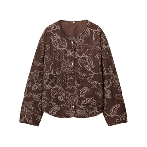 Close-up of brown quilted jacket featuring white floral patterns and large patch pockets