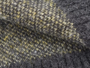Close-up of premium knit fabric with thick gray and yellow mohair fibers for luxury vest
