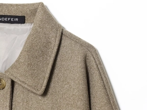 Close-up of lapel collar, button detail, and grey satin lining on brown wool jacket