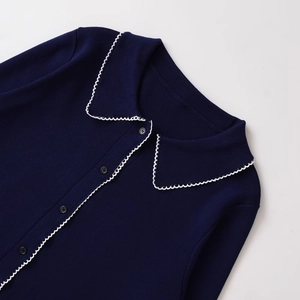 Navy blue knit cardigan with scalloped white trim and classic polo collar design