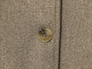 Close-up of marble texture button and premium wool-like fabric on cropped jacket