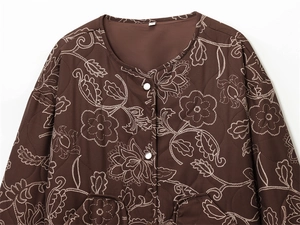 Detail of floral embroidery on a quilted dark brown jacket with white buttons