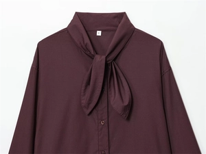 Close-up of wine red poplin shirt with elegant bow tie neck and branded size S label