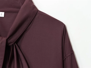 Close-up of poplin shirt with scarf tie neckline and size S label in burgundy red