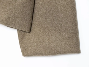 Detailed close-up of brown wool-like fabric texture showing soft fuzzy material surface