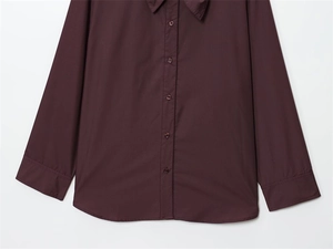 Detail of burgundy scarf collar poplin shirt with button-down front and long sleeves
