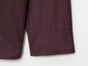 Detailed close-up of stitching on burgundy poplin shirt cuffs with fine double-thread seams