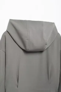 Detail of hooded dark grey jacket with twill texture and reinforced stitching