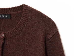 Close-up of deep red knit cardigan showing round neck and smooth matching buttons