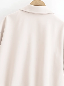 Detail view of the back collar and woven texture on a beige zip-up jacket for women