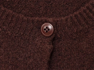 Macro detail of high-quality brown knit fabric with a four-hole resin button closure