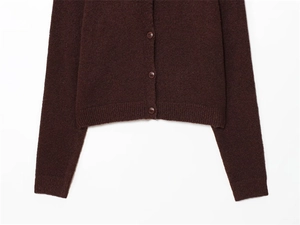 Detailed macro view of the ribbed cuffs and buttons on a brown knitted cardigan sweater