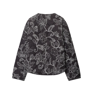 Detail view showing black quilted jacket back with white floral and paisley embroidery