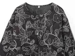 Detail of floral embroidery on black quilted jacket with single-breasted buttons
