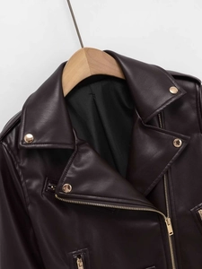 Détail d'un blouson moto marron foncé en similicuir avec fermetures éclair dorées