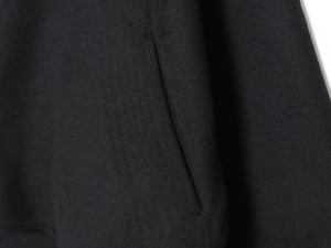 Close-up detail of side pocket on black soft faux-wool jacket with fine stitching