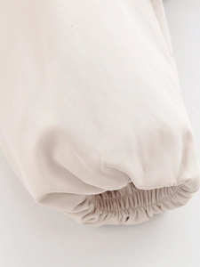 Detail of elastic ribbed cuffs on a cream white street style jacket with tight stitching
