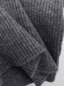 Nahaufnahme der gerippten Strickstruktur eines dunkelgrauen Kurzarmpullovers für Damen
