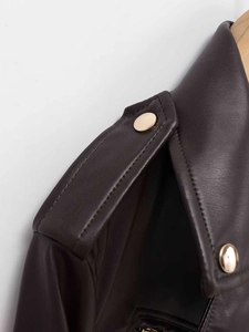 Détails des épaulettes à boutons dorés sur une veste en similicuir marron foncé