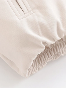 Detailed macro view of beige jacket cuff with premium ribbed texture and reinforced stitching