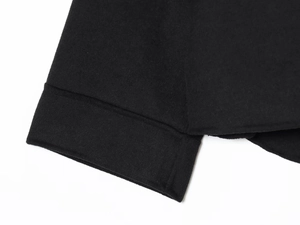 Detail shot of black soft wool-like jacket sleeve showing fabric texture and neat stitching