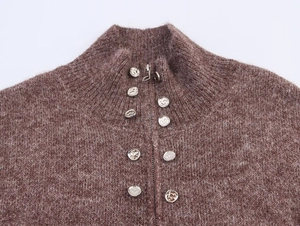 Close-up of deep brown fuzzy knit sweater with half-zip collar and silver metal buckles
