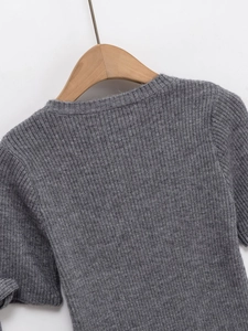 Nahaufnahme des dunkelgrauen Strickoberteils mit Rippstruktur und weichem Wollstoff