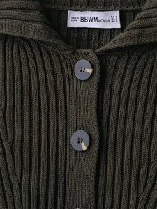 Macro detail of dark olive ribbed knit cardigan showing collar label and buttons