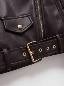 Détails d'une veste de motard noire en similicuir avec zip doré et ceinture à boucle