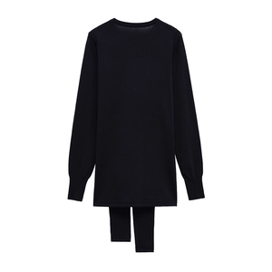 Close-up of black long sleeve knit top with decorative scarf detail and ribbed cuffs