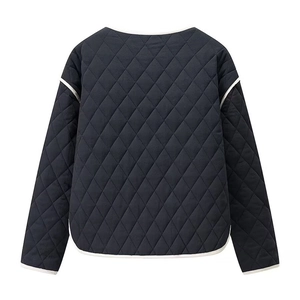 Detail of black quilted jacket with classic diamond pattern and white contrast piping