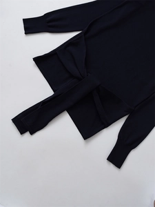 Detail of knit sweater showing ribbed cuffs and elegant crisscross waist tie design