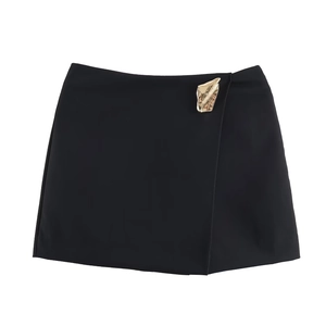 Detail des schwarzen A-Linie Mini-Skorts mit Wickeldesign und goldener Blattschnalle
