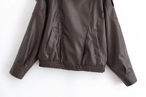 Detail of dark brown faux leather jacket featuring lychee texture and elastic hemline